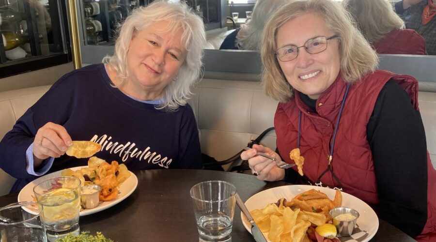 Two friends enjoy a lunch of trout and chips at Palate Restaurant in the National Museum of Wildlife Art. Taken on a Teton Excursions private winter tour of Grand Teton National Park.