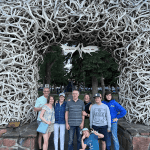 Family poses beneath the antler arch in Town Square, Jackson, WY. taken on a Teton Excursions tour to Yellowstone National Park