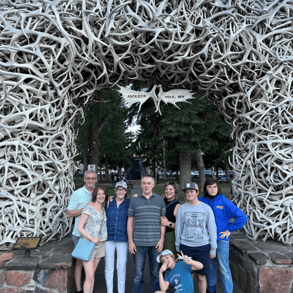 Family poses beneath the antler arch in Town Square, Jackson, WY. taken on a Teton Excursions tour to Yellowstone National Park