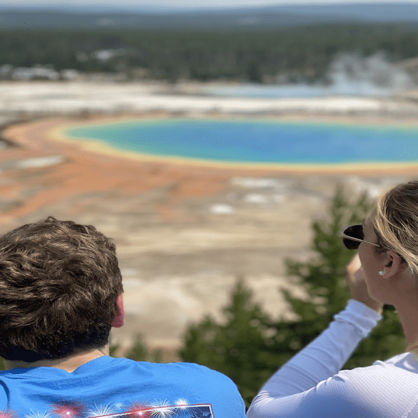 Backshot of a young couple at the Grand Prismatic Overlook, Yellowstone National Park, taken on a Teton Excursions tour to Yellowstone National Park